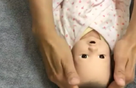 赤ちゃん人形をベビーマッサージしている画像